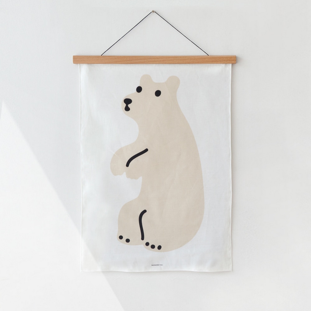 Stoffposter Fabric Poster Huggy Bear Cream mit heller Holzleiste haengt an weisser Wand.
